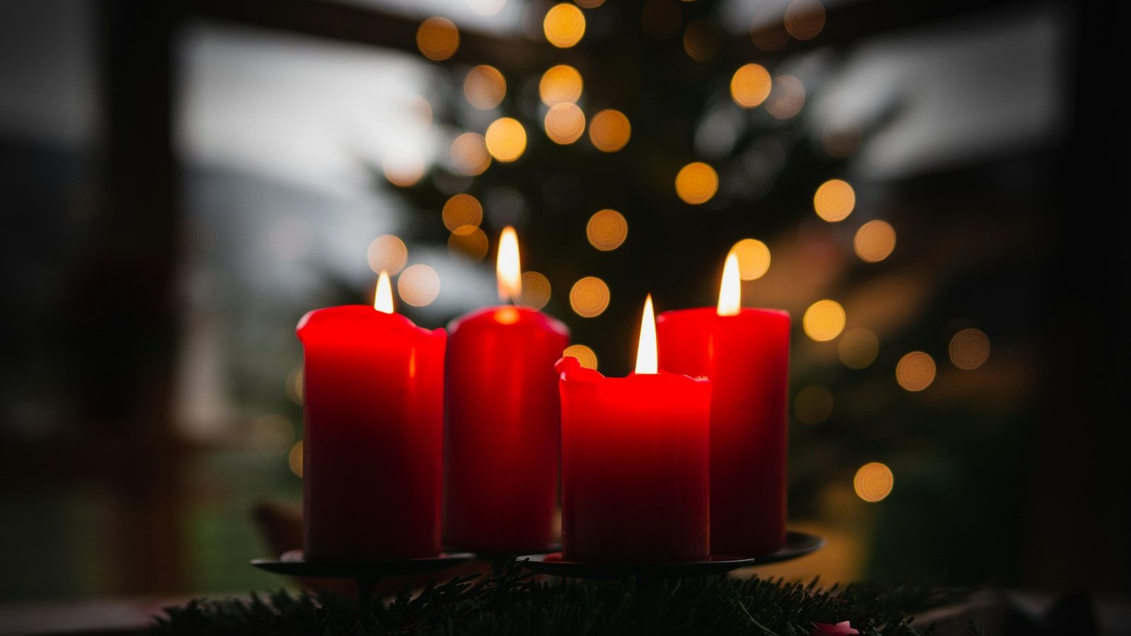 shallow focus photo of four red lighted candles