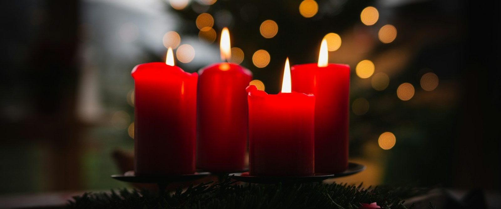 shallow focus photo of four red lighted candles