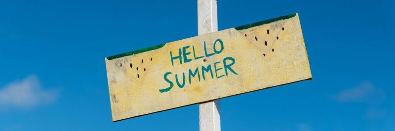 A cheerful 'Hello Summer' sign against a bright blue sky, symbolizing the joyous arrival of summer.